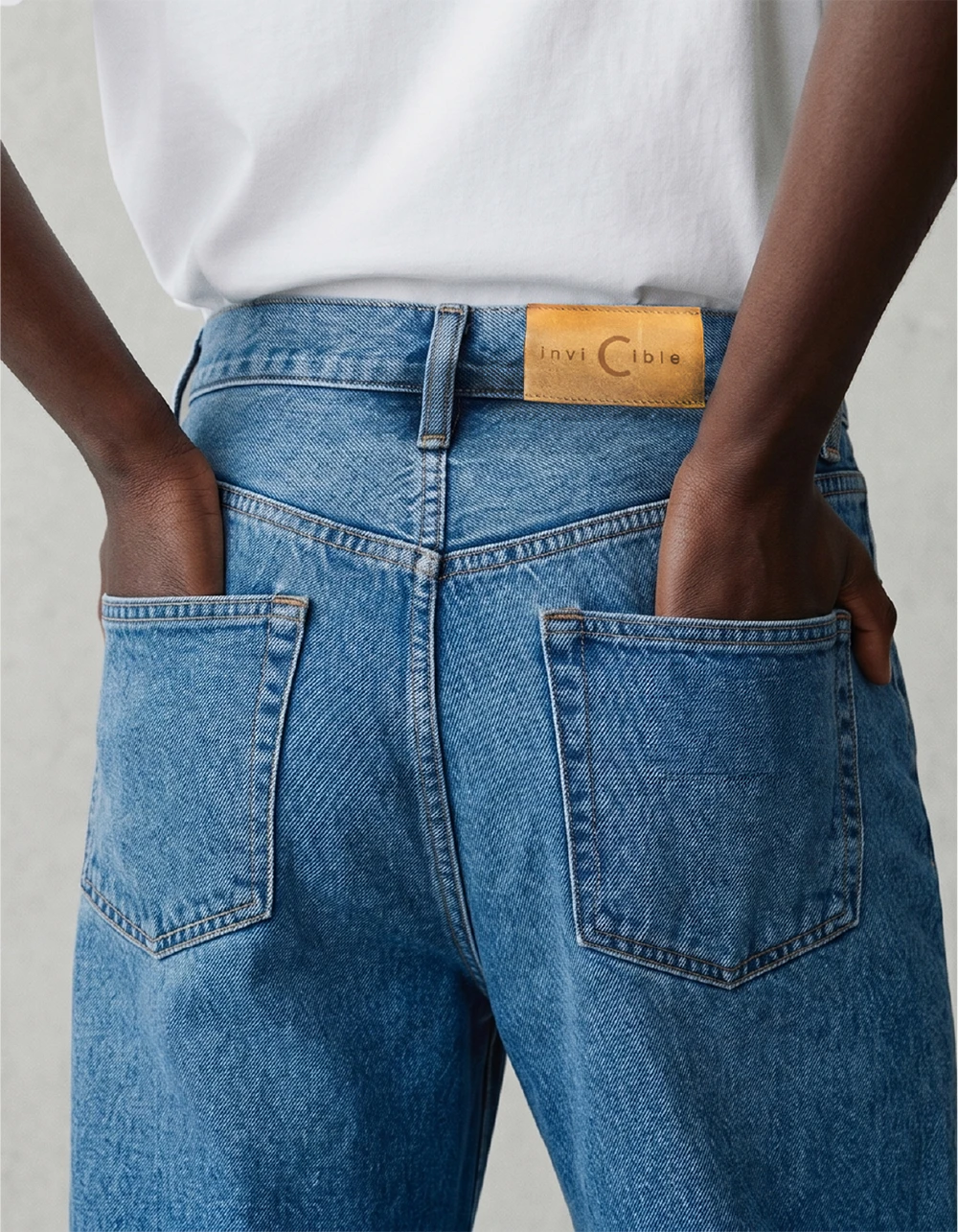Modelo invicible vista trasera — denim con etiqueta de cuero